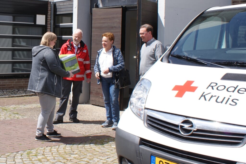 José van Boxmeer en Wilchard Cooijmans van de PCI en Fred Tijssen van het Rode Kruis reiken het eerste voedselpakket uit
