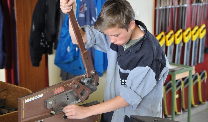 Een jongen volgt praktisch onderwijs.