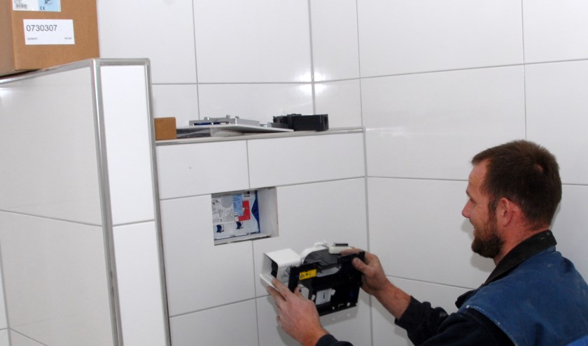 Een installateur van Alferink Installatietechniek bouwt een van de Geberit DuoFresh inbouwreservoirs in.