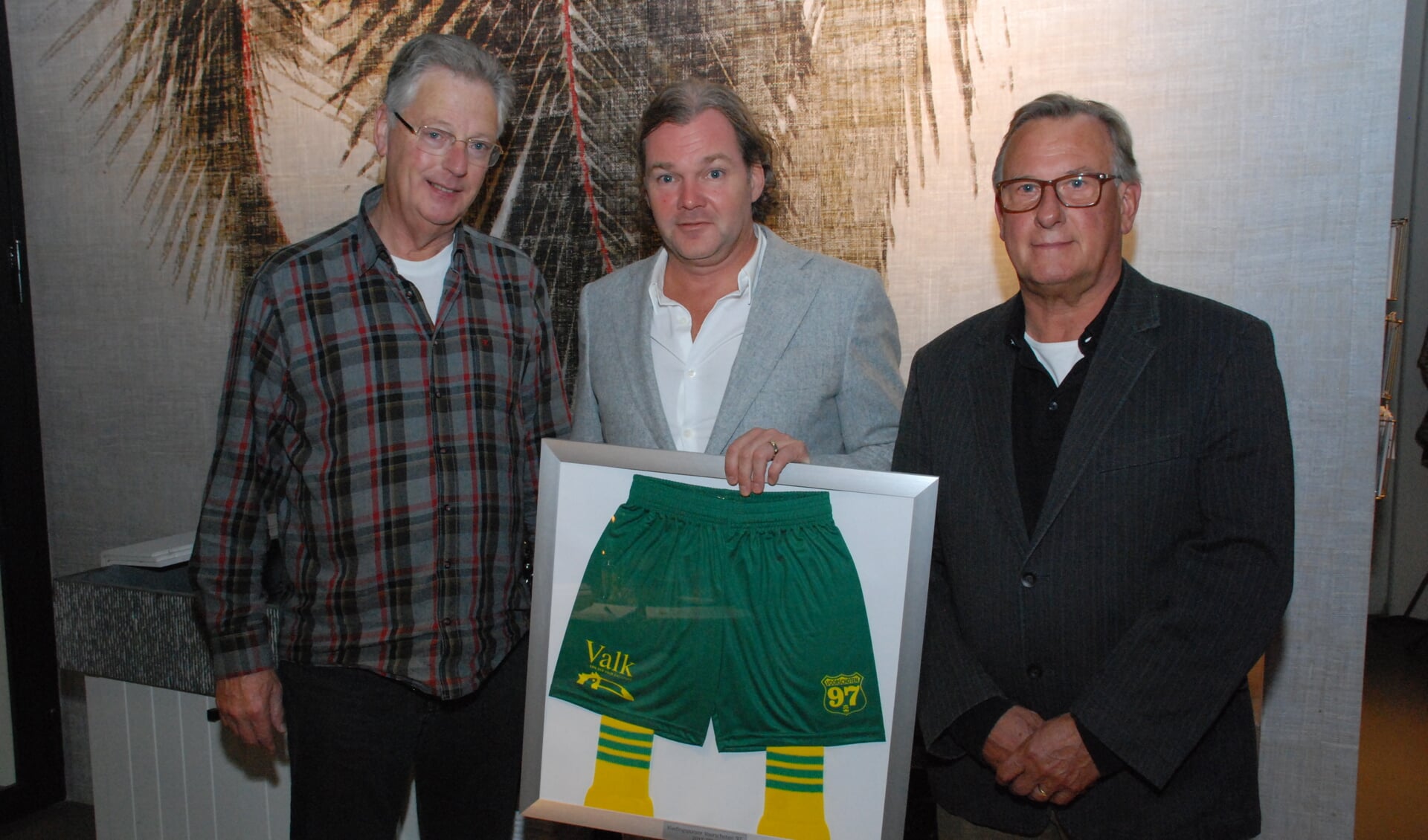 Marcus van der Valk (midden) met de ingelijste voetbalbroek met links Voorschoten '97 voorzitter Ton van Emmerik en rechts Hans Toor, voorzitter van de sponsorcommissie.