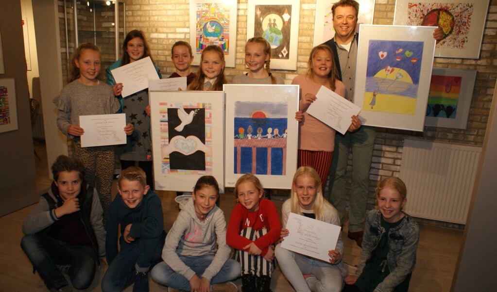 Een aantal winnaars van de Peace Poster wedstrijd met Lions voorzitter Erwin Lunshof. Foto: VSK