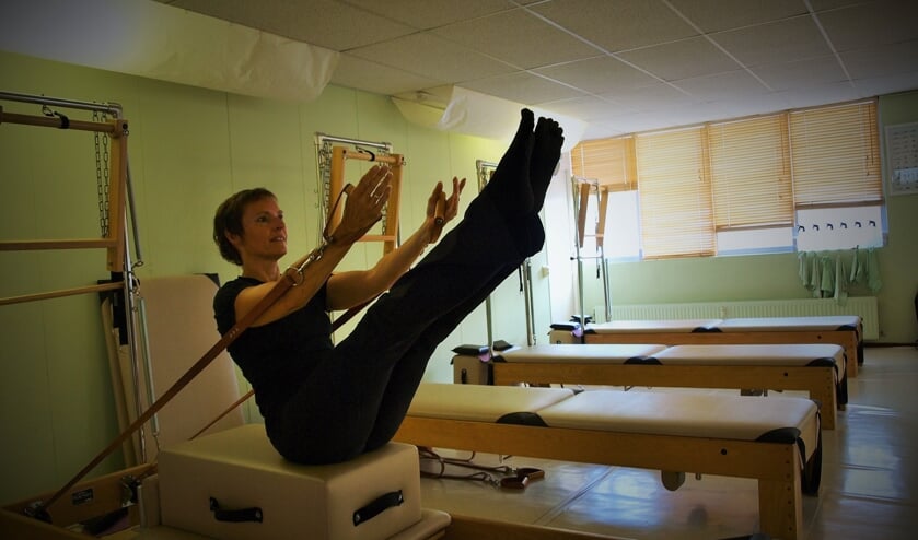Sylvia Temmink demonstreert een pilates oefening op de Peak Pilates trainingsbank. Foto: Vsk