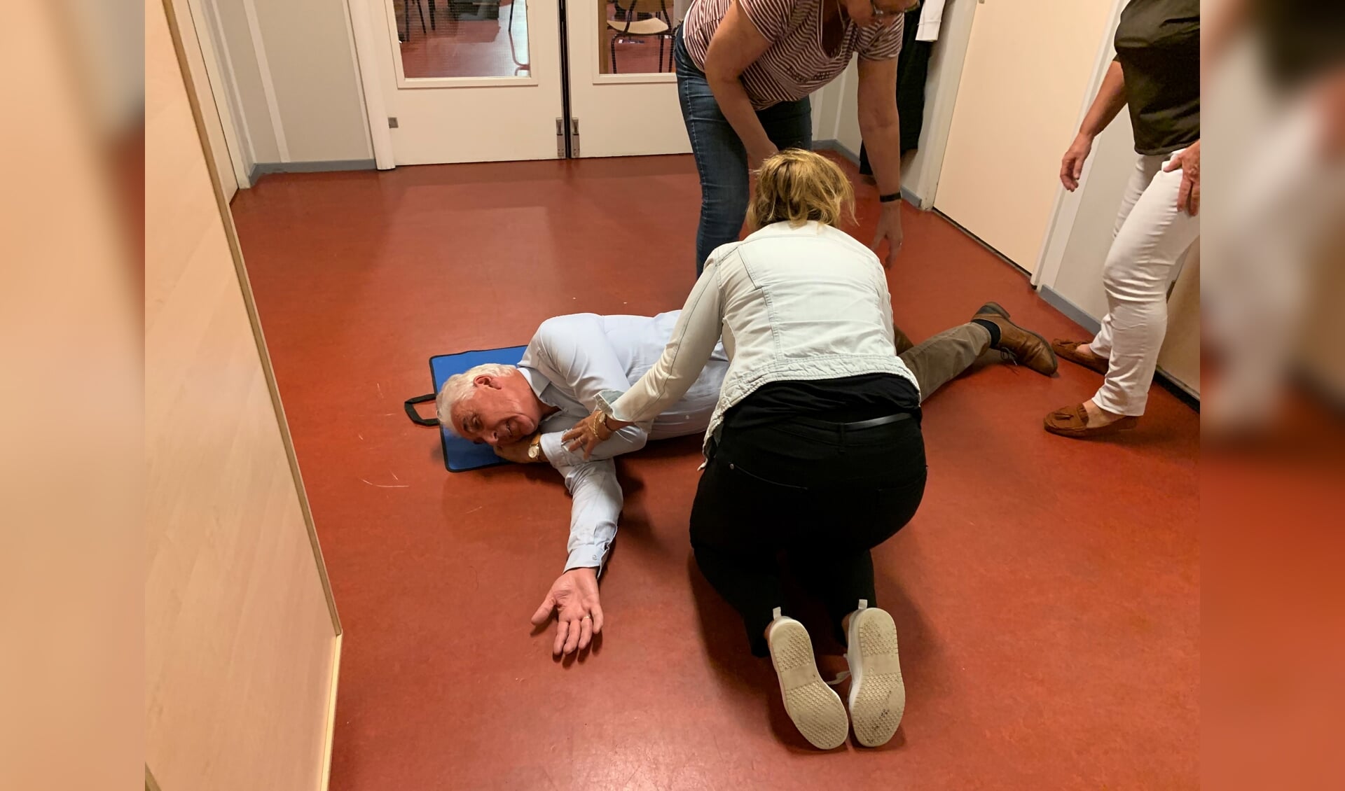 Fotohandelaar Hans van den Boogaardt toont zich een gewillig slachtoffer bij een demonstratie van een stabiele zijligging tijdens een reanimatiecursus voor Voorschotense bedrijven (Foto: Jasper Suijten)