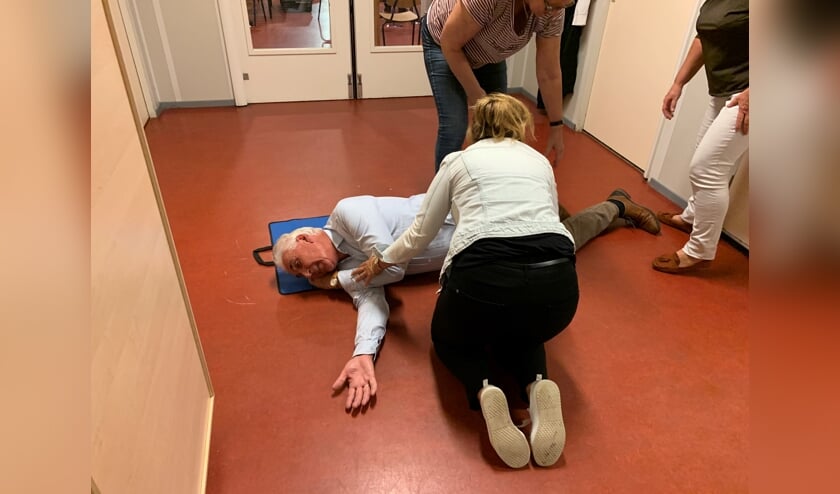 Fotohandelaar Hans van den Boogaardt toont zich een gewillig slachtoffer bij een demonstratie van een stabiele zijligging tijdens een reanimatiecursus voor Voorschotense bedrijven (Foto: Jasper Suijten)