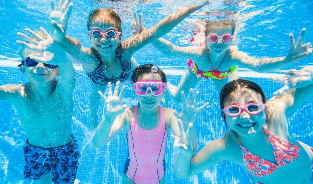 little kids swimming  in pool  underwater.