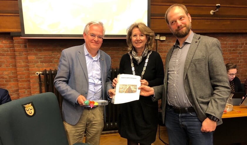 Erik Maassen van de SP heeft de uitkomsten van de enquête in de gemeenteraad aangeboden aan wethouder Cramwinkel en burgemeester Bouvy. Foto: VSK