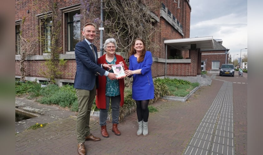 Coördinator VoorleesExpress Fariidah van Leeuwen (Stichting JES Rijnland) biedt Wethouder Nanning Mol een eerste exemplaar van het onderzoek 'Werkt de VoorleesExpress?' aan. Foto: VSK