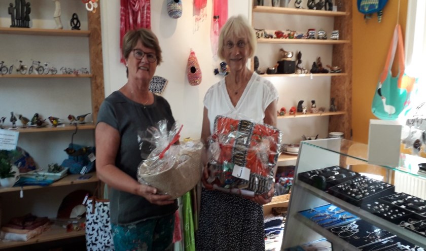 Trots tonen medewerkers van de Wereldwinkel enkele cadeaupakketten van de loterij.