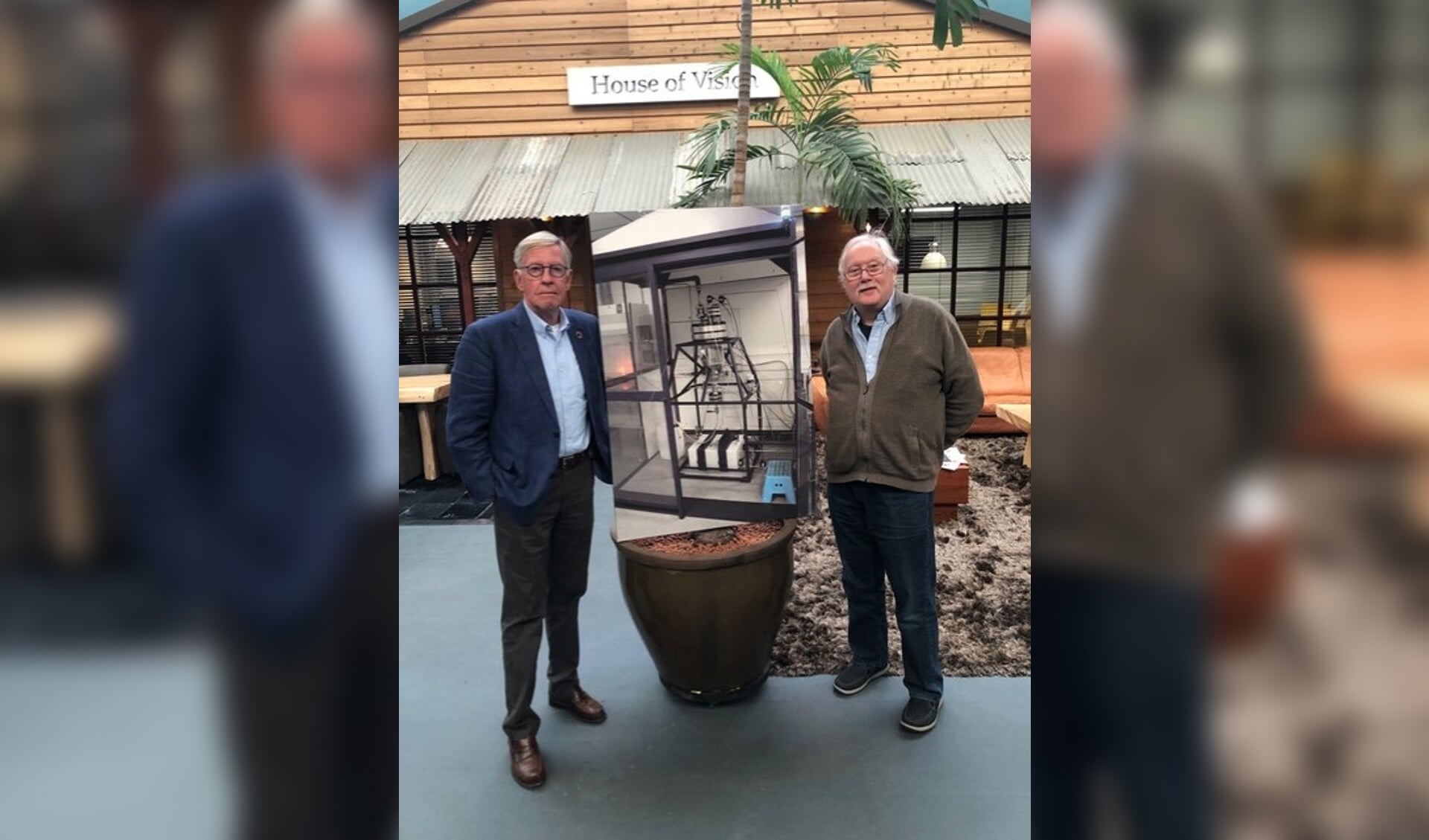 Jan Willem Kelder (l) met Gerard Lugtigheid, de uitvinder van de h2fuel techniek in de hal van House of Vision met een grote foto van de H2Fuel generator die op PlantOne Botlek Rotterdam staat. Foto:PR