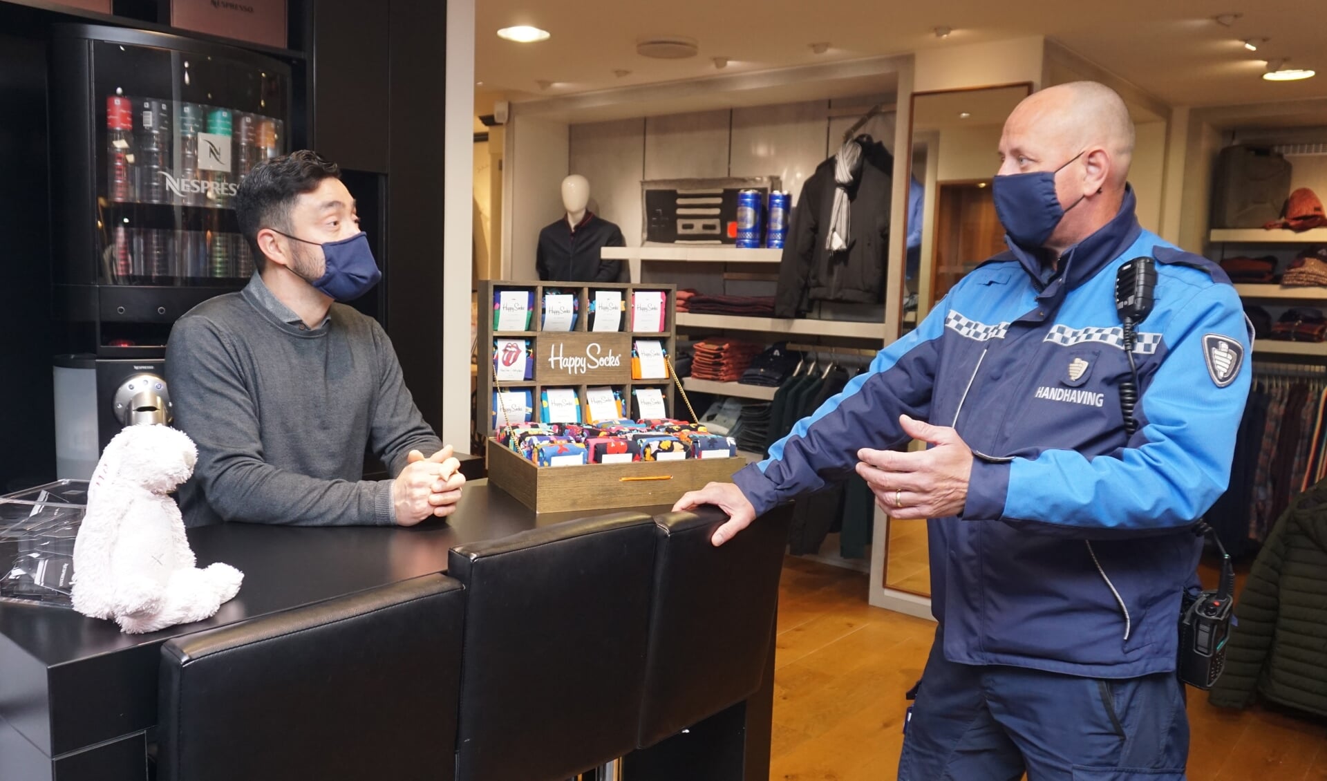 BOA Jeroen Stam in gesprek met Carlos van Wees over de mondkapjesplicht. Wat moet je doen als er iemand binnen komt zonder kapje? Foto: VSK 