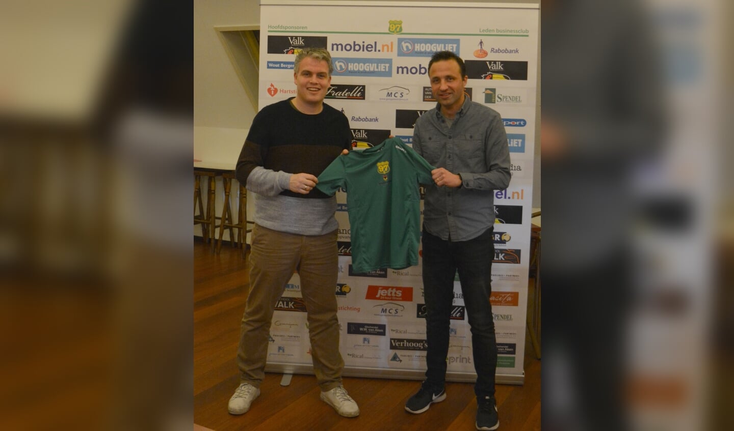 Matthijs Ferguson (interim-voorzitter Voorschoten'97 Atletiek) en sponsor Mathieu Hilgersom (Hilgersom Tekstproducties) tonen het nieuwe shirt.