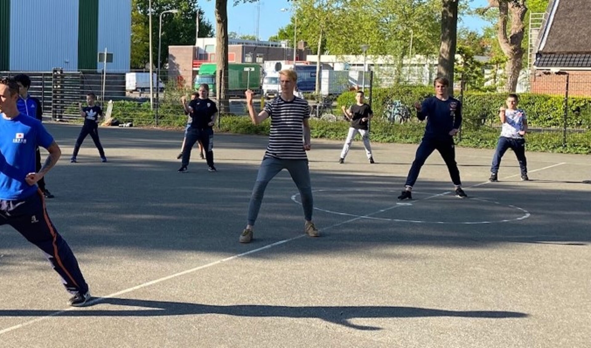 Taekwondo jeugdtraining op teerveldje achter de sporthal de Vliethorst