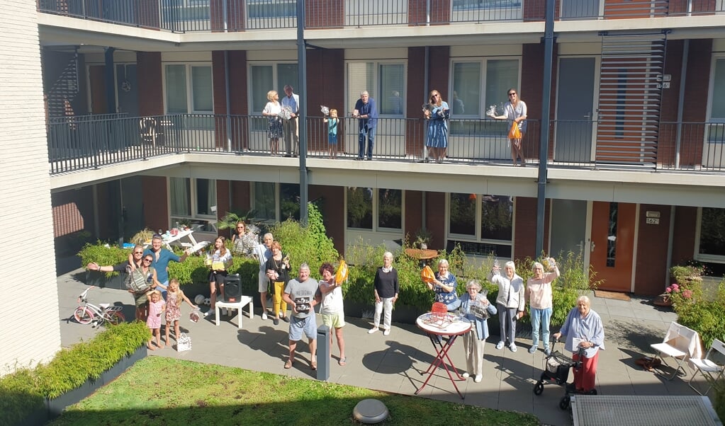 Met anderhalve meter afstand of op het balkon, de bewoners genoten van het laatste coronafeestje, georganiseerd door de buren Martijn, Robert en Denise. Foto: PR
