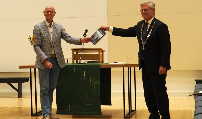 Burgemeester Aptroot krijgt het eerste exemplaar van '1000 jaar Dorpskerk' uitgereikt   