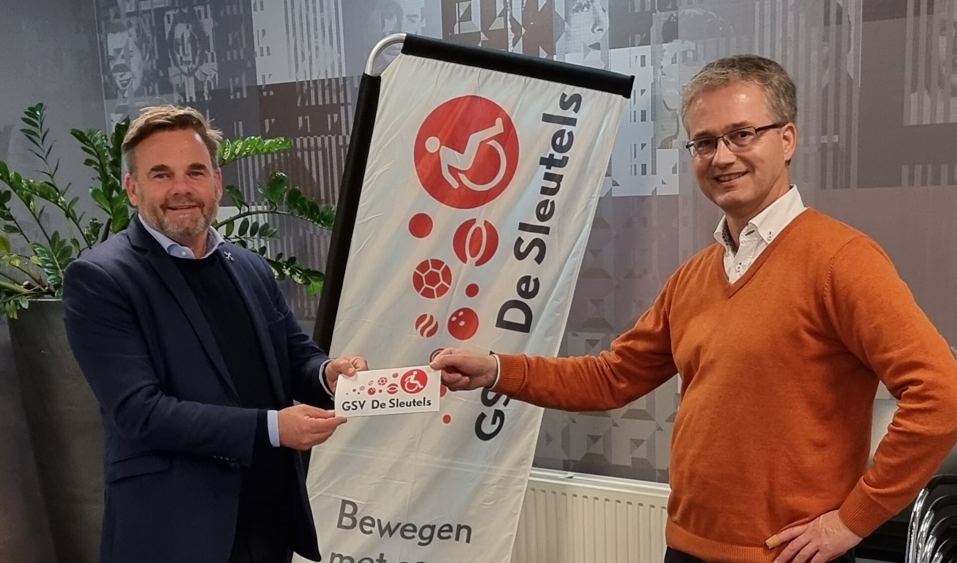 De Leidse wethouder Paul Dirkse (links) ontvangt de flyer van Sleutels-voorzitter Marnix Zwart (rechts). Foto: GSV De Sleutels.