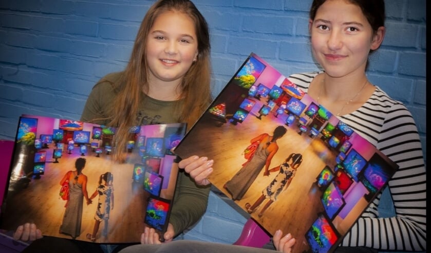 <p>Joëlle en Soraya kregen allebei het bijzondere boek van Jan van der Horn. Hij maakte zelf de foto in de bibliotheek. </p>