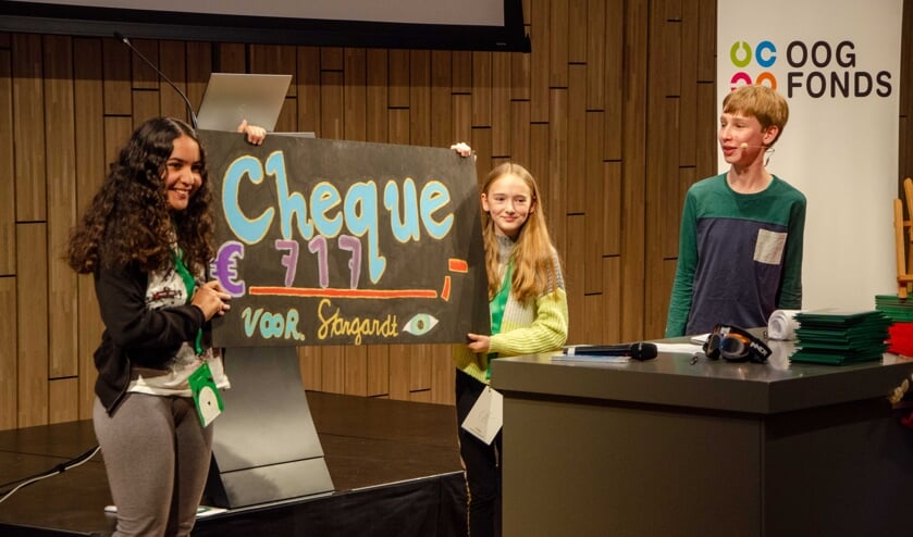 <p>Corné krijgt van zijn klasgenootjes de cheque overhandigd. Alles gaat naar het Oogfonds voor onderzoek. Foto: Oogfonds</p>
