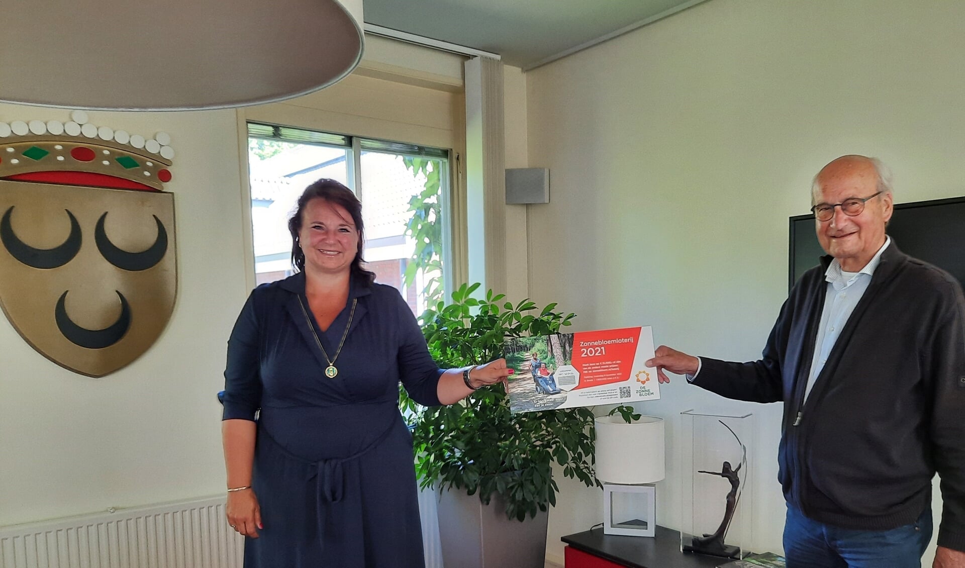 Burgemeester Nadine Stemerdink kocht het eerste Zonnebloem lot in Voorschoten van Zonnebloemvoorzitter Rob van Gelder