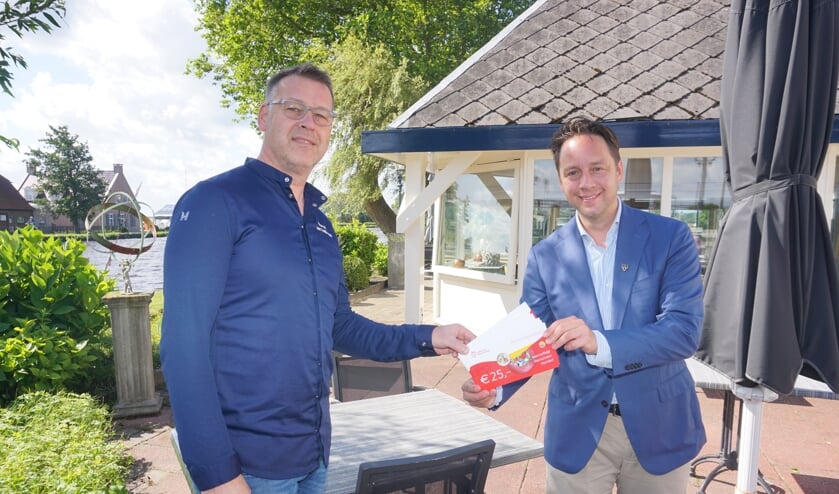 <p>Marcel van Teijlingen (l) van Restaurant De Knip ontvangt als eerste de Voorschotense Voordeel Horecabonnen van wethouder Paul de Bruijn. </p>
