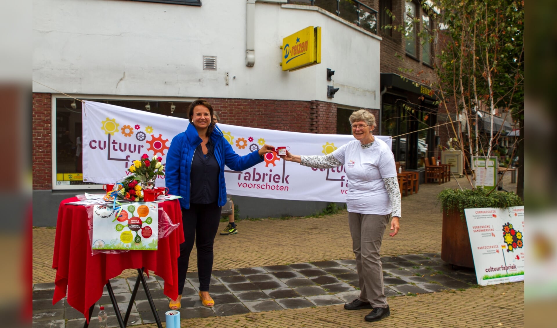 Burgemeester Nadine Stemerdink (links) ontvangt Cultuurfabriek gietertje uit handen van Maria Huijts (rechts) (foto: Cultuurfabriek Voorschoten)