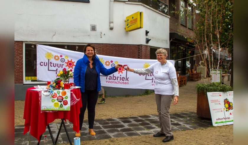 <p>Burgemeester Nadine Stemerdink (links) ontvangt Cultuurfabriek gietertje uit handen van Maria Huijts (rechts) (foto: Cultuurfabriek Voorschoten)</p>