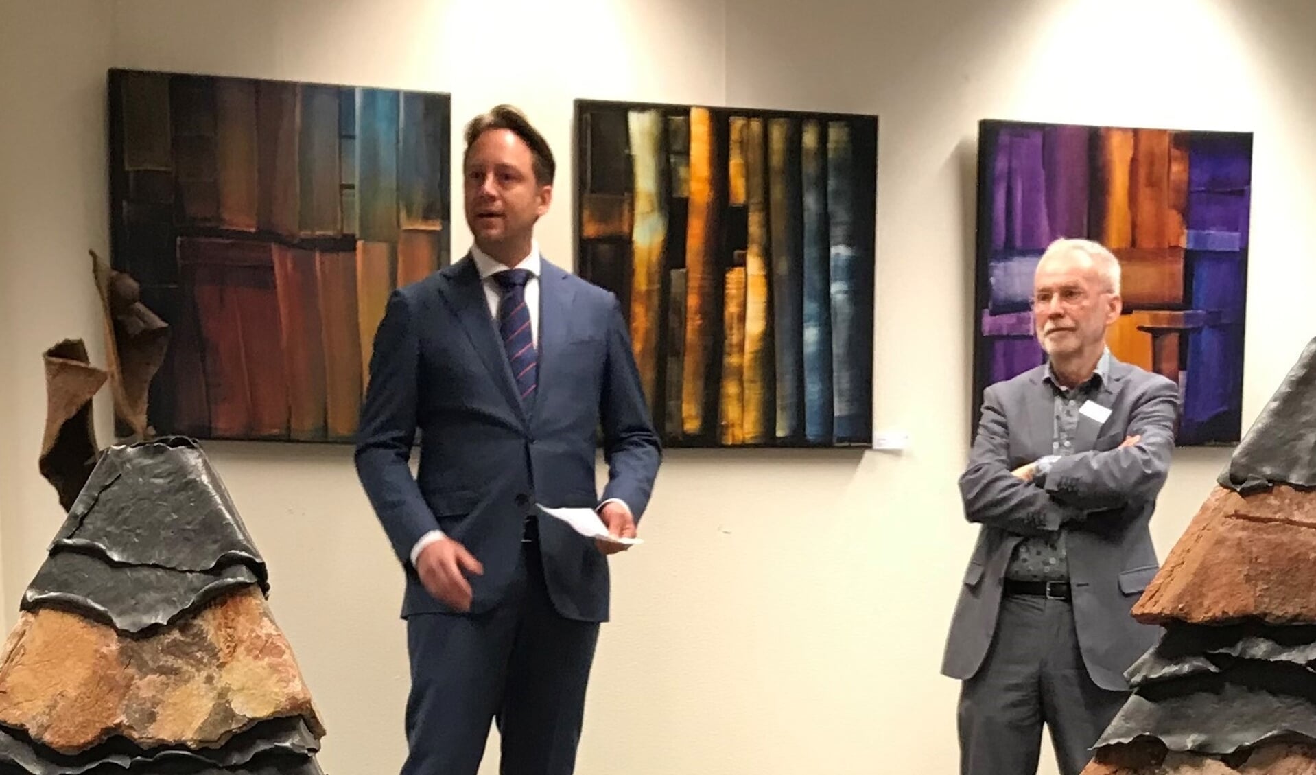 Wethouder Paul de Bruijn (l) en VKK-voorzitter Bert Westra midden tussen de prachtige kunst bij de opening van de expositie WeerZien op 26 februari in Den Haag. (Foto: Jozef Sloots)