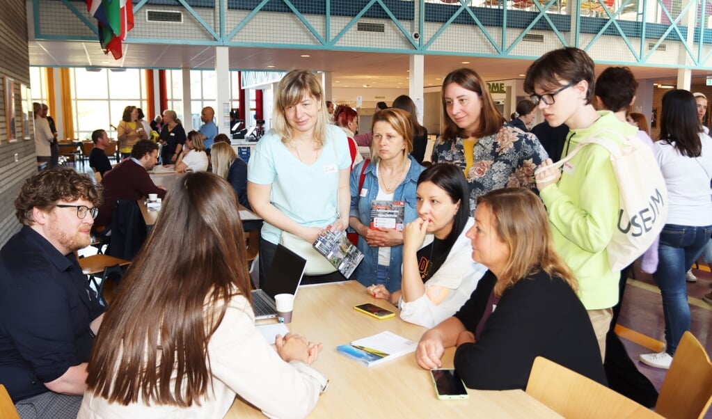 Veel belangstelling van Oekraïense vluchtelingen aan de tafels van de bedrijven tijdens de banenmarkt in The American School of The Hague op zaterdag 7 mei (Foto: Anton Overklift)