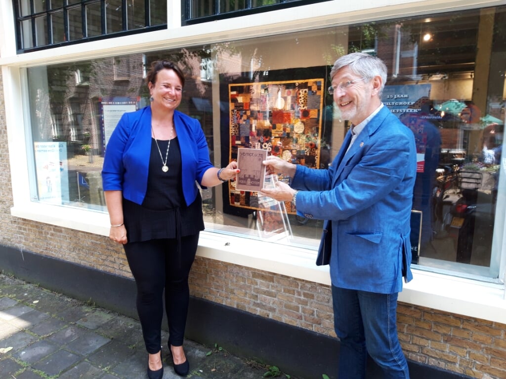 Burgemeester Stemerdink krijgt uit handen van museumvoorzitter Hans Rasch het eerste herdrukte boekje. Foto: PR
