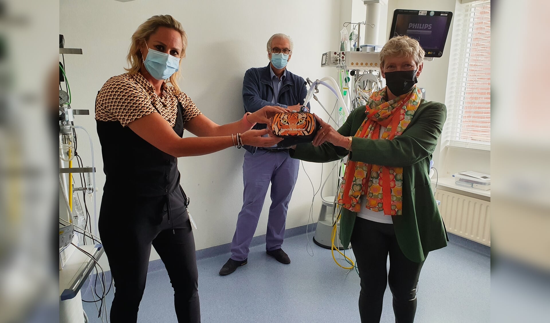 Afdelingshoofd Marieke van Splunter (links) ontvangt één van de brillen van Arna de Wit, penningmeester van de stichting.
