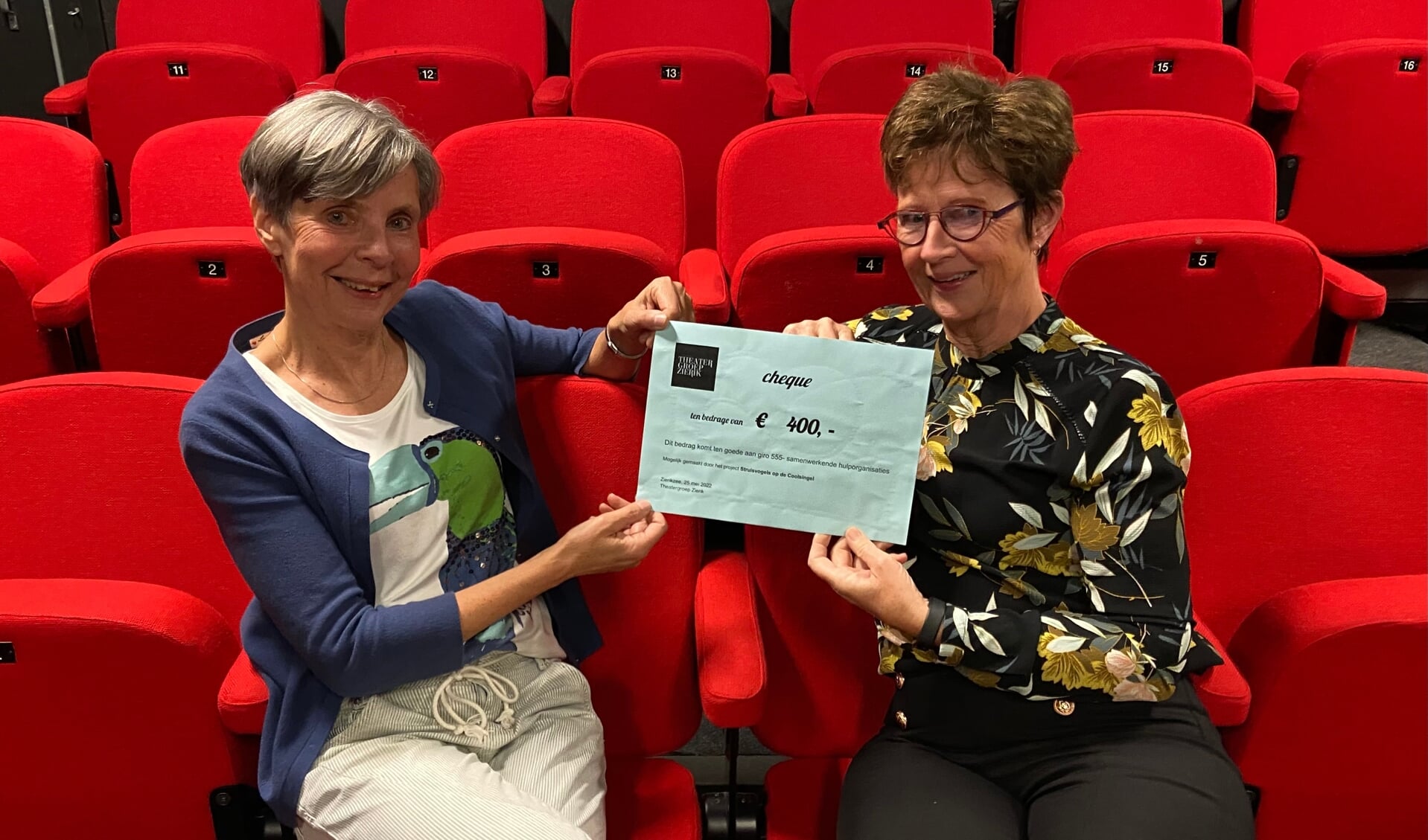 Regisseurs Yolanda Smits (l) en Nelleke Tamerus overhandigen namens Theatergroep Zierik een cheque voor Giro555 t.w.v 400 euro.