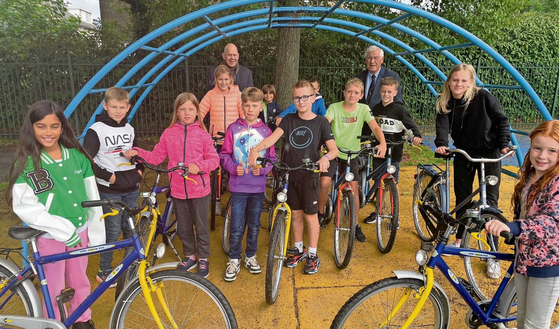 De kinderen op de nieuwe fietsen met Sybren Singelsma en Rob Visser op de achtergro