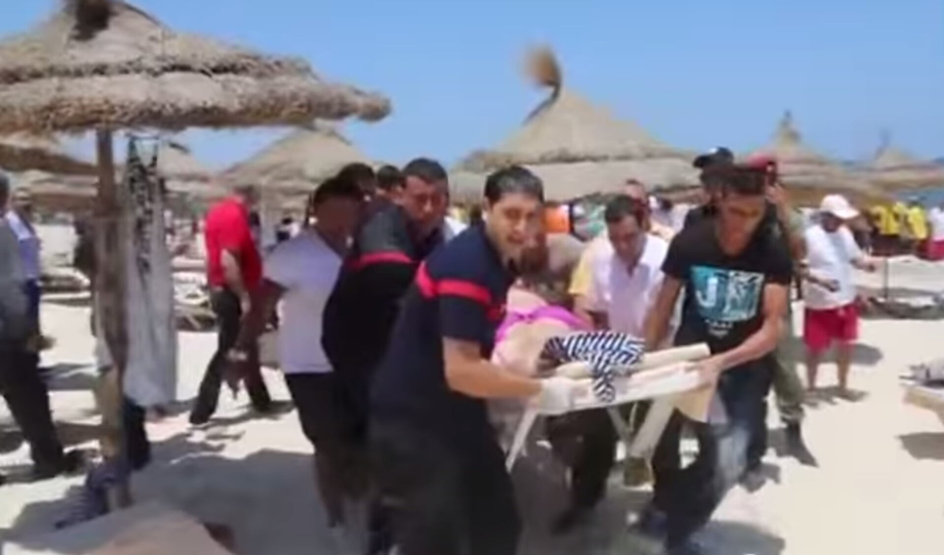 Gewonden worden door hulpverleners van het strand gedragen. Videostill: YouTube