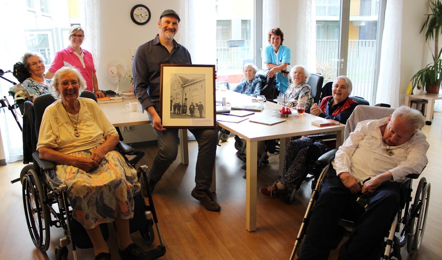 Erik Bevaart met één van de lijsten. Links zijn moeder die onlangs ook is 'neergestreken' in de Weidevogelhof. Verder op de foto: mevrouw Knoll, mevrouw Kemp, mevrouw Van Peer, meneer Goedhart en mevrouw Van Lier. Het gezelschap wordt geflankeerd door moeder en dochter Saskia en Celesta, beiden werkzaam bij Pieter van Foreest. Foto: Martijn Mastenbroek
