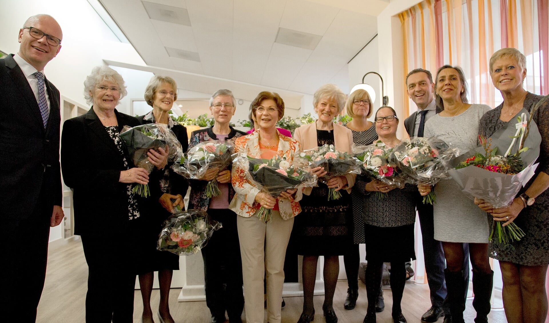 Burgemeester Tigelaar (r.) met de vrijwilligers en coordinatoren van het hospice (foto: Adrey Caljé).