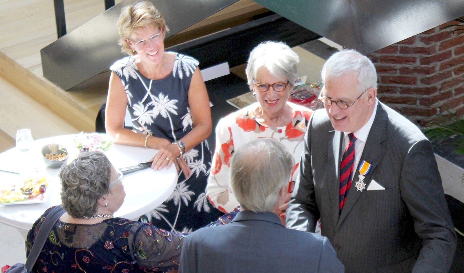 De onderscheiden burgemeester Hans van der Sluijs, geflankeerd door zijn echtgenote, tijdens de afscheidsreceptie (foto: Dick Janssen).