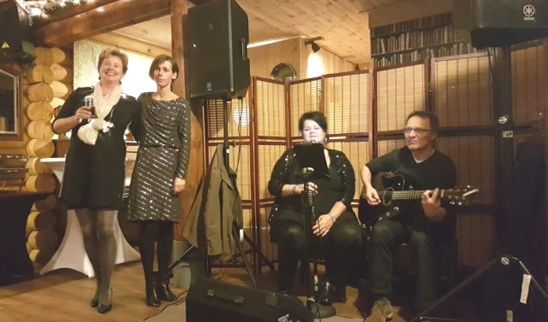 Sonja en Manon genieten met hun vrijwilligers van de muziek van Johan Nühn en Linda Galle.