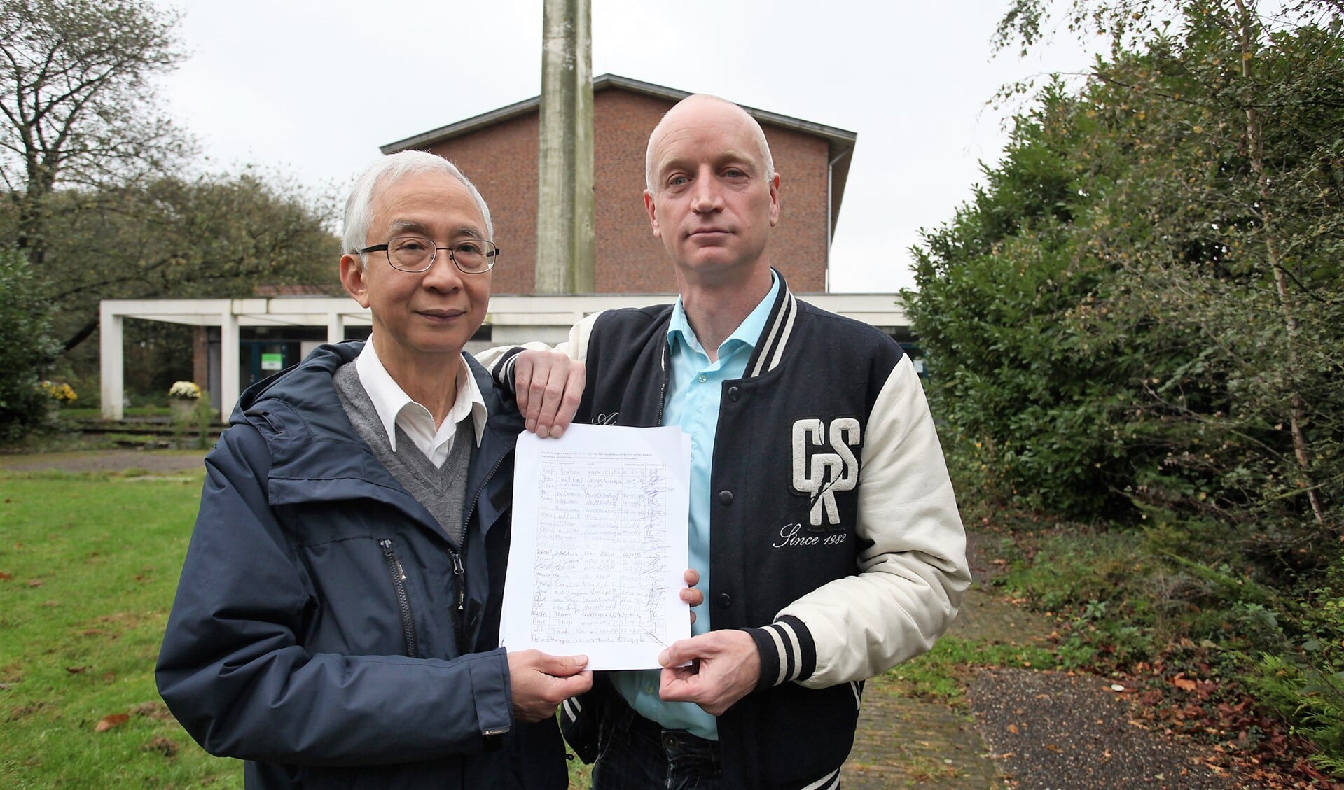Hans van Ierland enTik Ong tonen de lijsten met handtekeningen van buurtbewoners (tekst: Inge Koot/foto: Peter van Zetten).