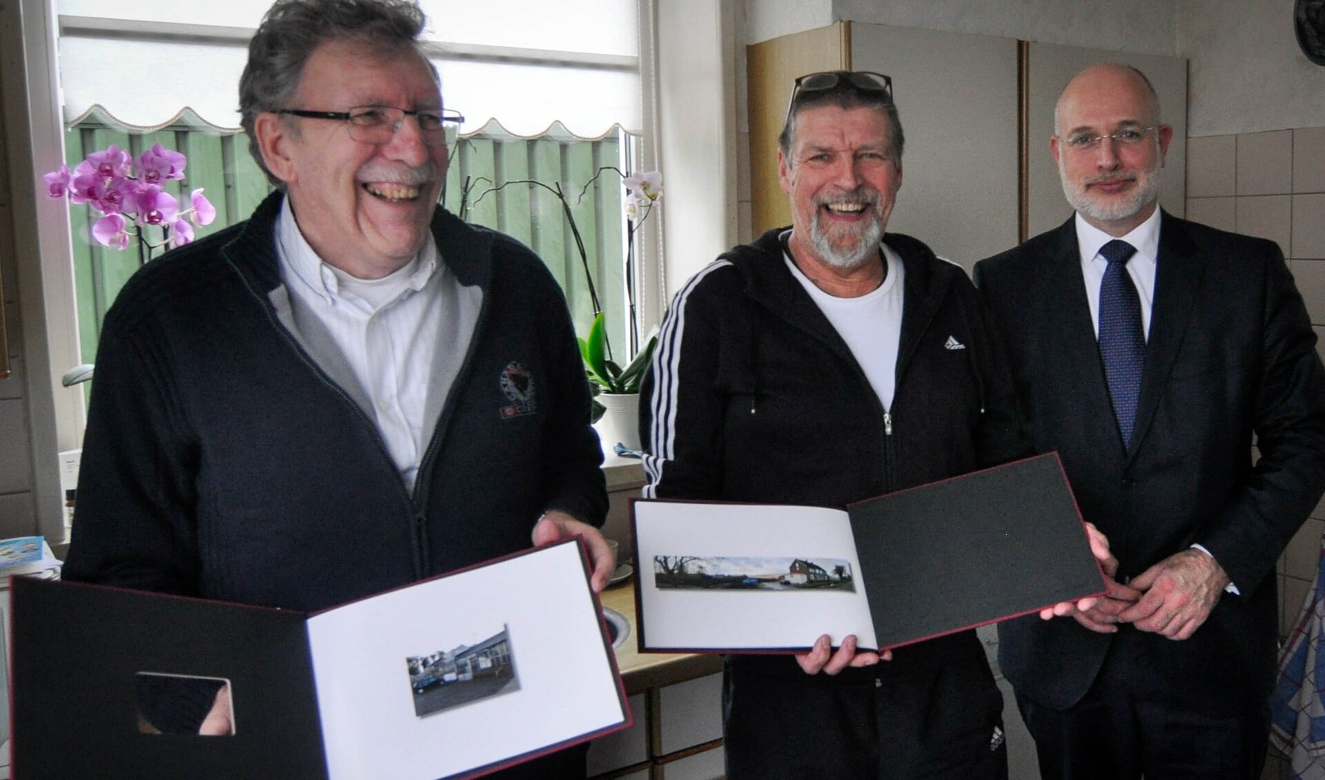 De gebroeders Goeman met het fotoboek dat wethouder Frank Rozenberg overhandigde (foto: gemeente LDVB).