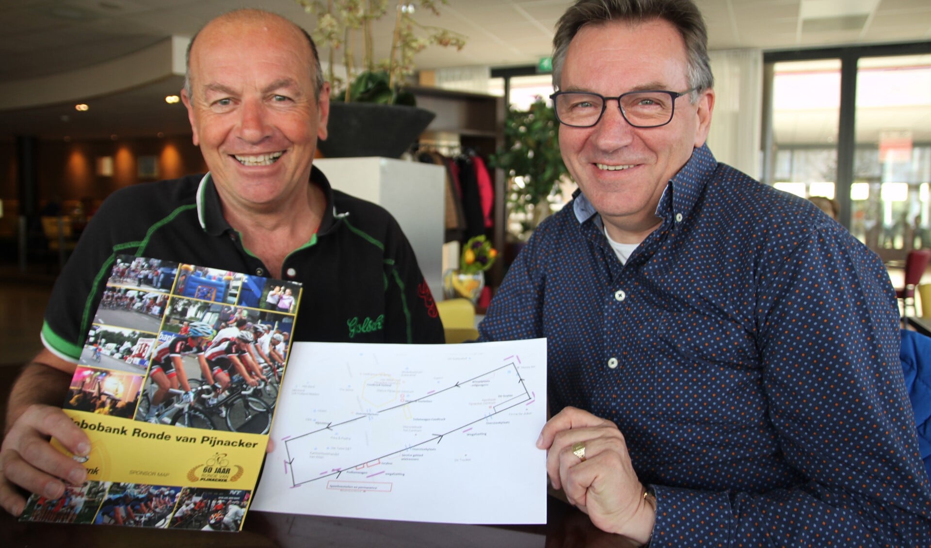 André Remmerswaal en Bert Bos met een tekening van het parcours en de wielerdagfolder. 