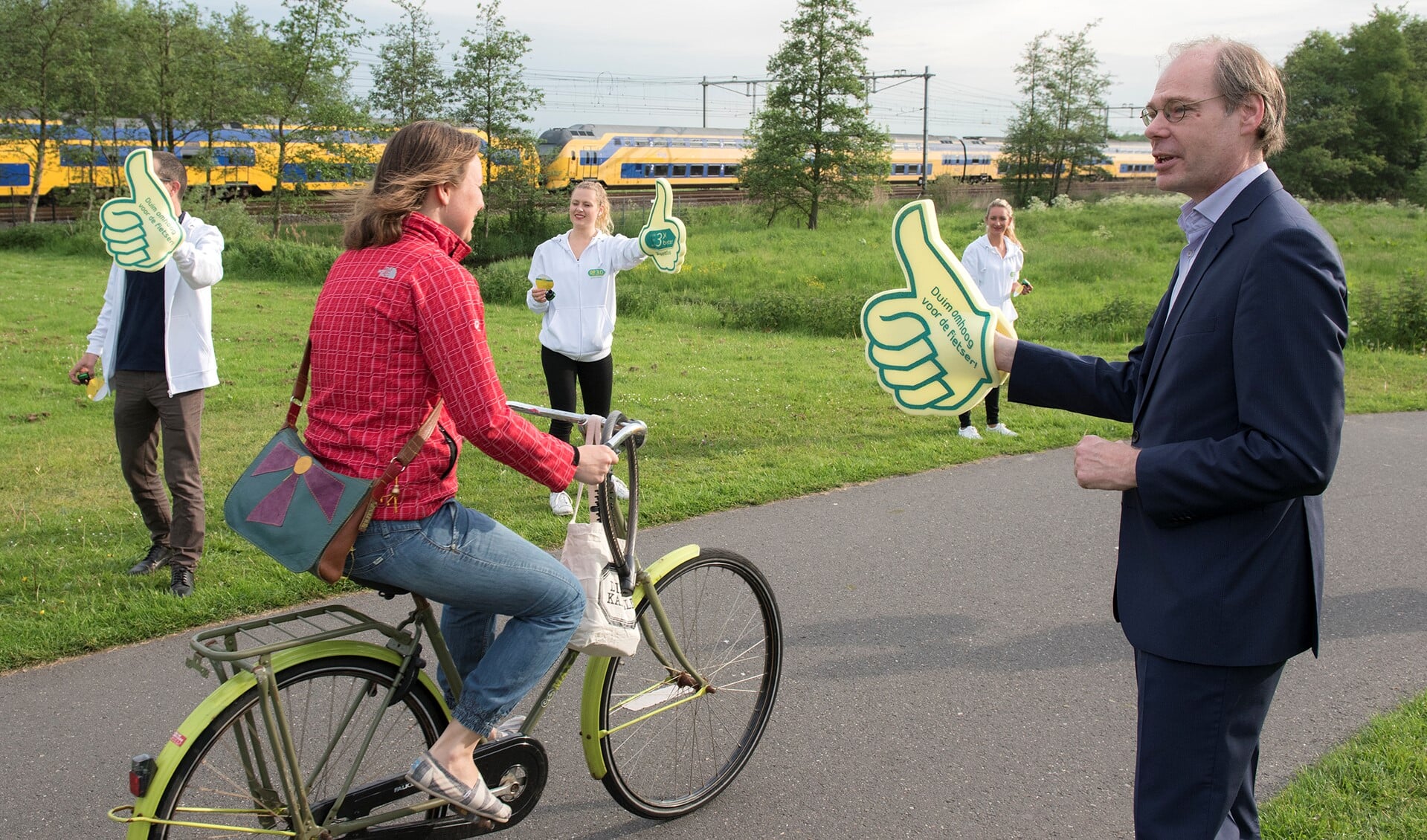 Wethouder Floor Kist steekt de duim op voor passerende fietsers (foto: Michel Groen).