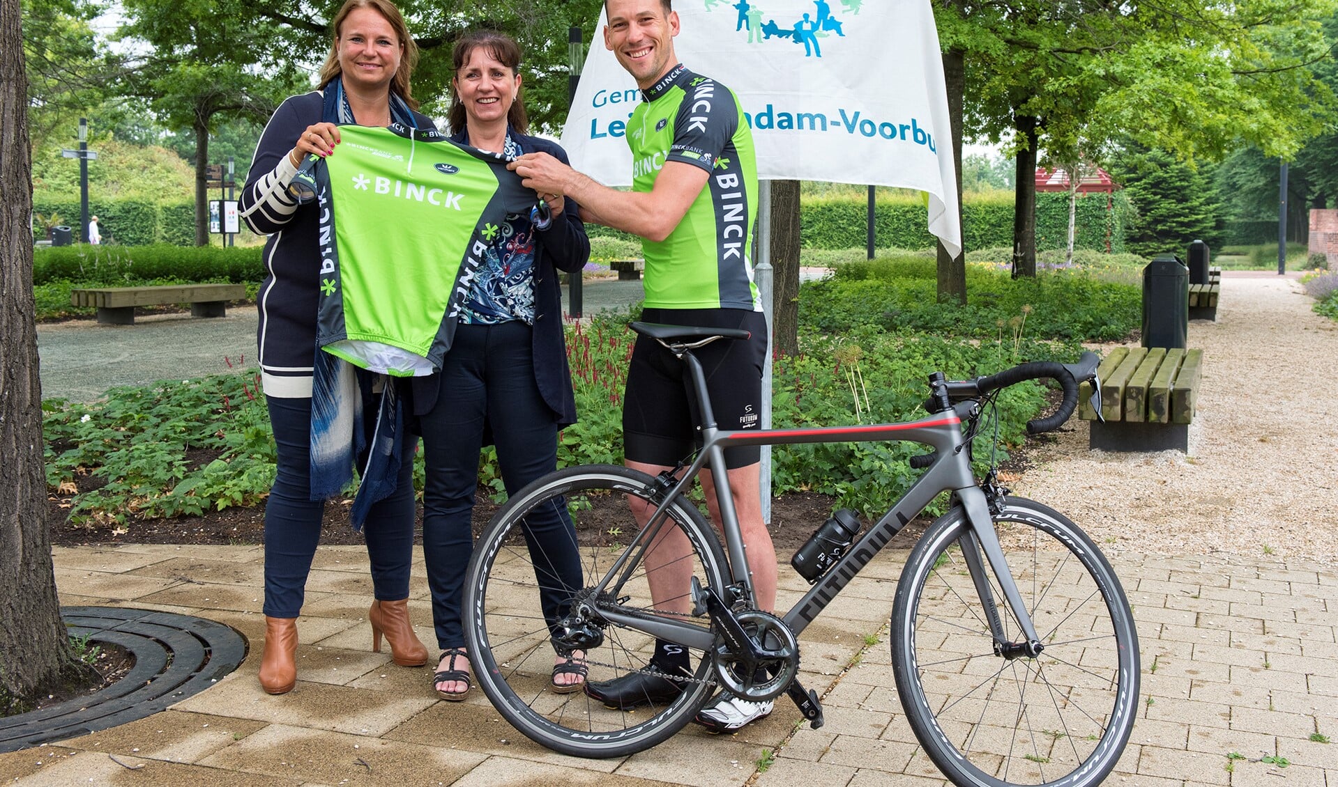 BinckBank Tour-ambassadeur en ex-topwielrenner Maarten Tjallingii overhandigde de eerste officiële groene BinckBank Tour-leiderstrui aan de  wethouders Bianca Bremer en Nadine Stemerdink (foto: Michel Groen).