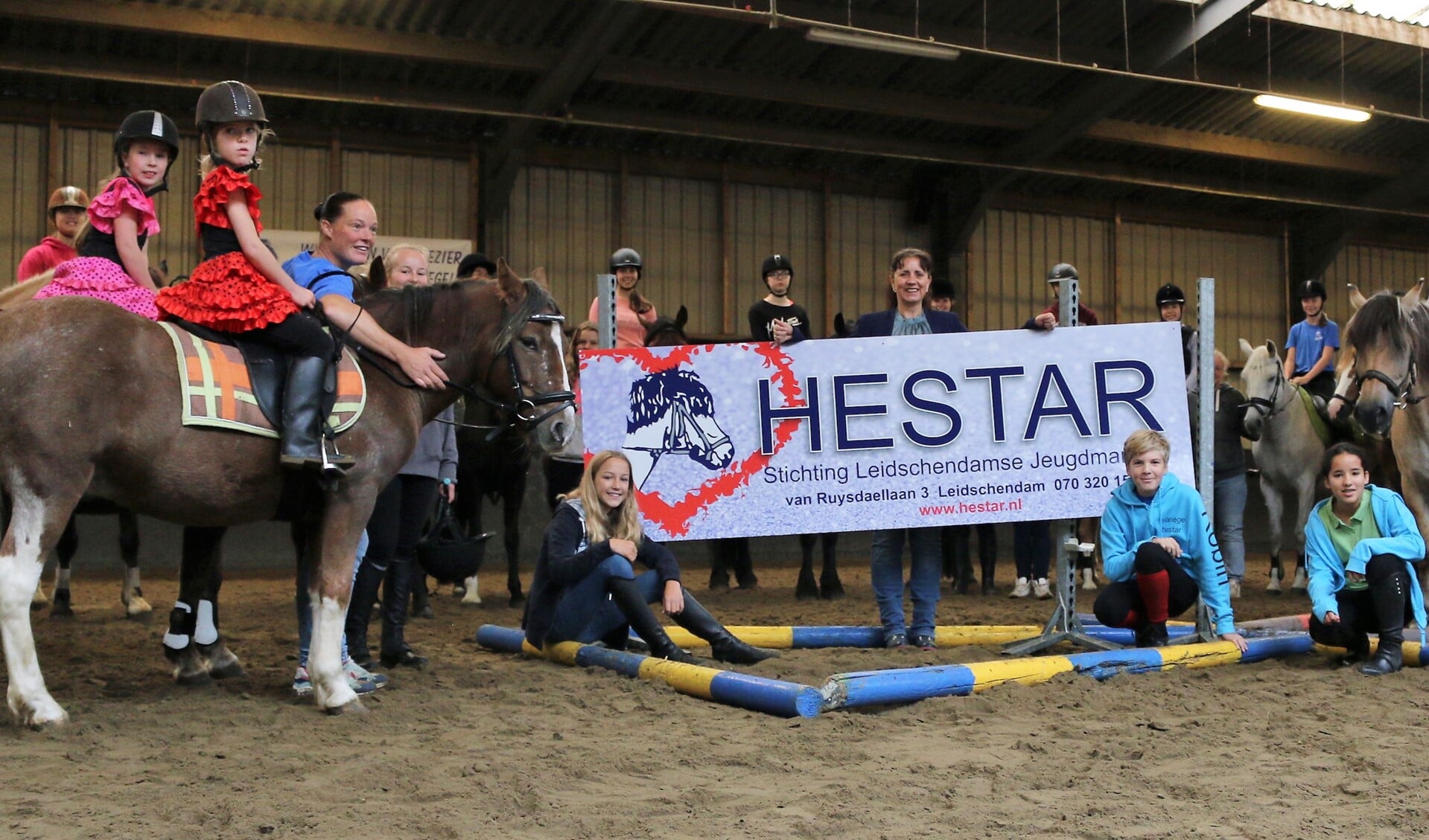 Aantal pony's en ruiters met wethouder Bremer in de binnenbak van manege Hestar (foto: pr Hestar).