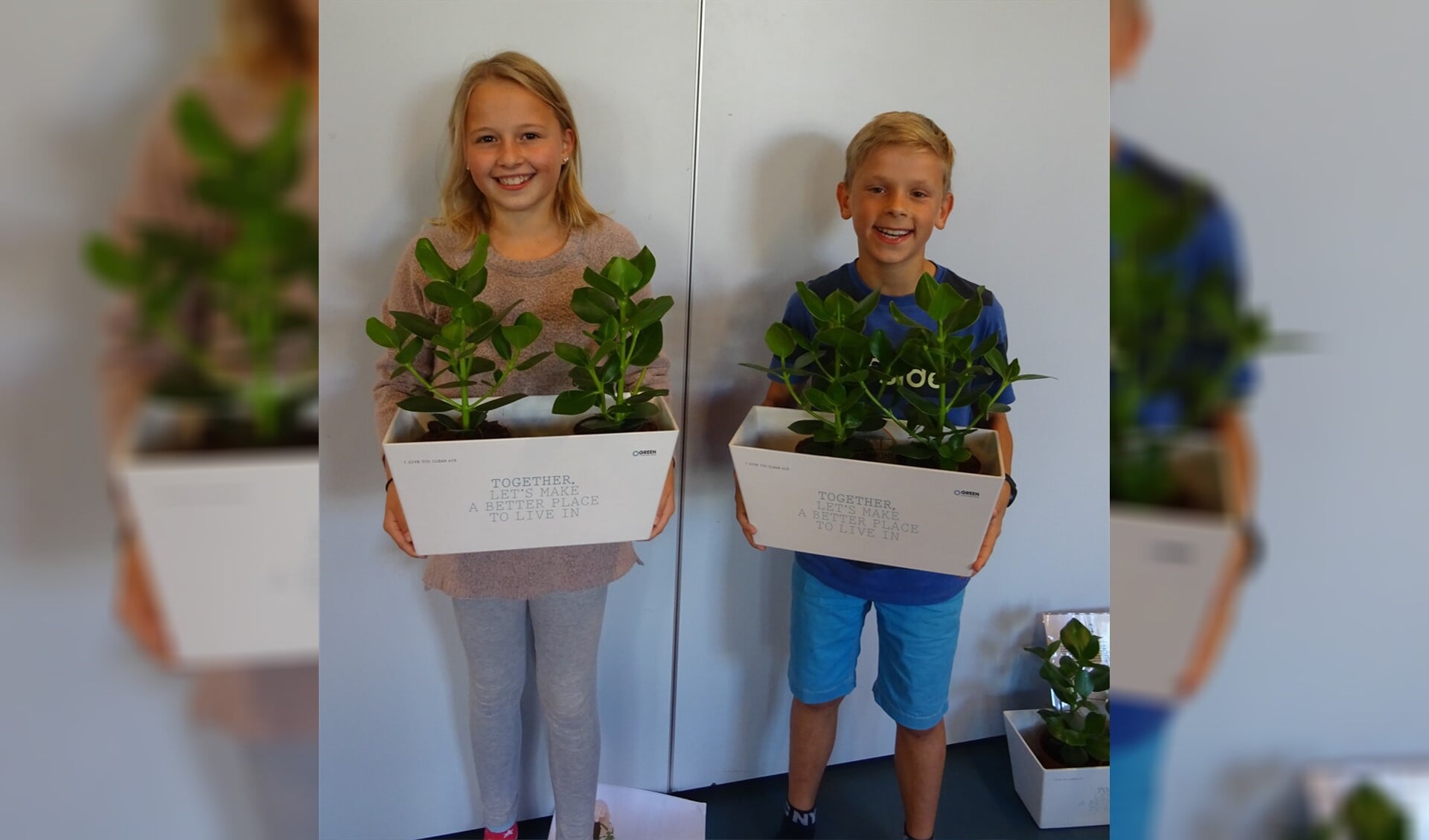 Niels en Yara uit groep 7/8 van o.b.s. de Meander nemen de eerste zuurstofplanten - een initiatief van de leerlingenraad - in ontvangst. (Foto: Petra Cos)