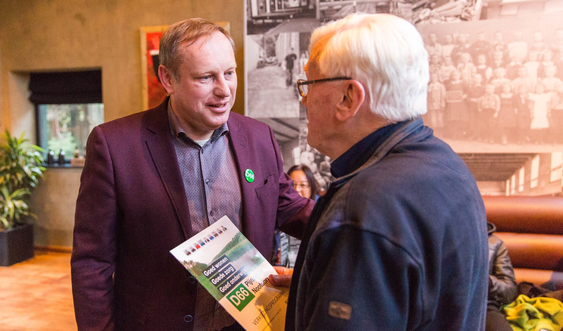 Peter Hennevanger biedt D66 nestor Ted Jas het eerste verkiezingsprogramma aan (foto: E. Mulder)