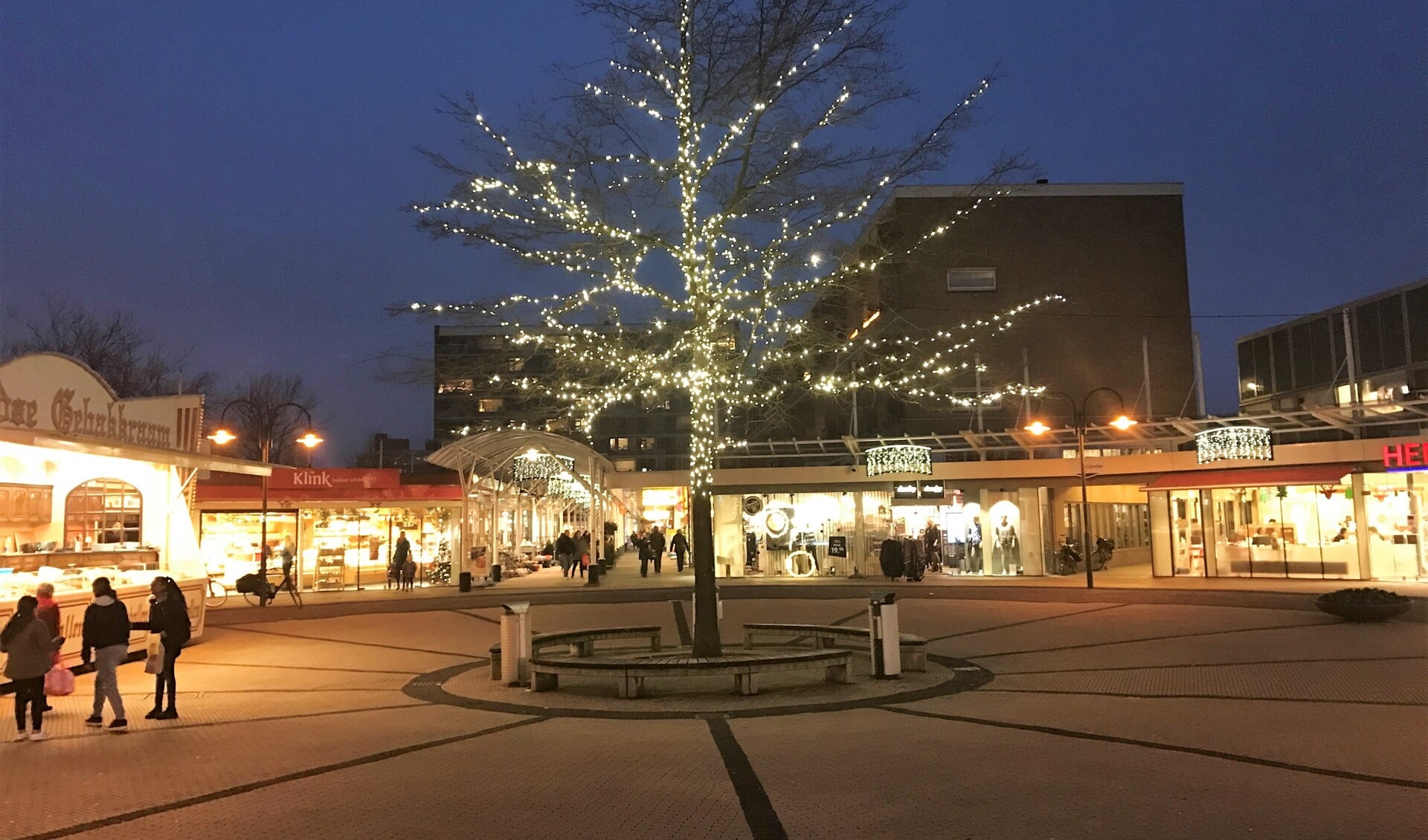 De boom op het centrale plein van De Julianabaan is voorzien van lichtjes en de winkels zijn voorzien van sfeervolle kerstversiering en -verlichting.