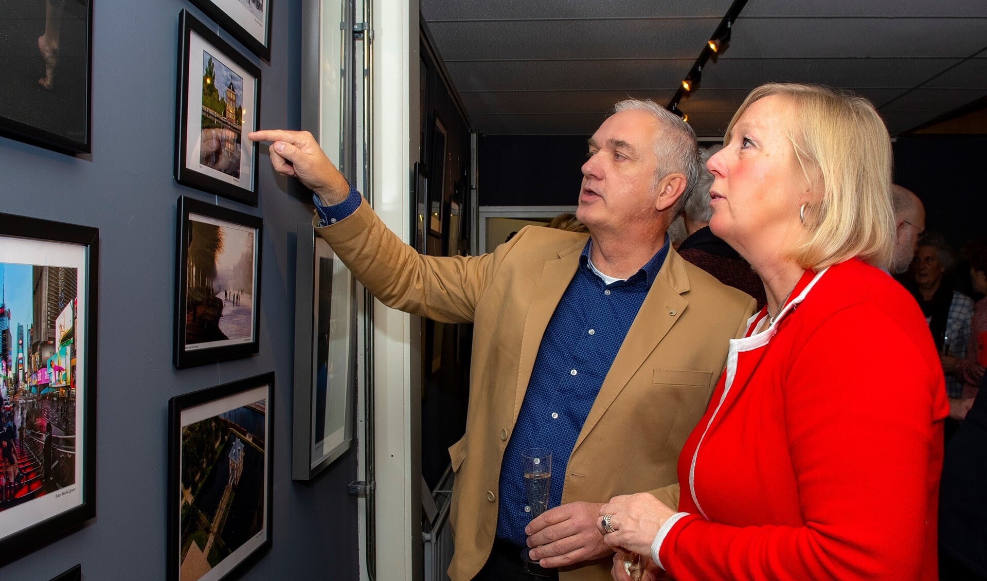 Fotograaf Michel Groen geeft wethouder Astrid van Eekelen uitleg bij de foto's (foto: Nico van der Ven).