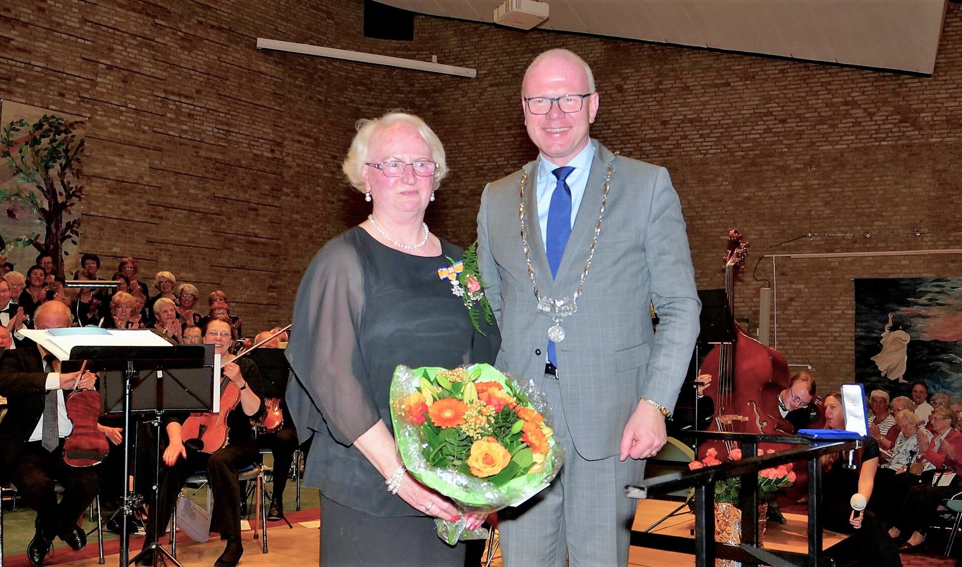 Burgemeester Klaas Tigelaar speldde mevrouw Magielse de Koninklijke onderscheiding op (foto: Ot Douwes).