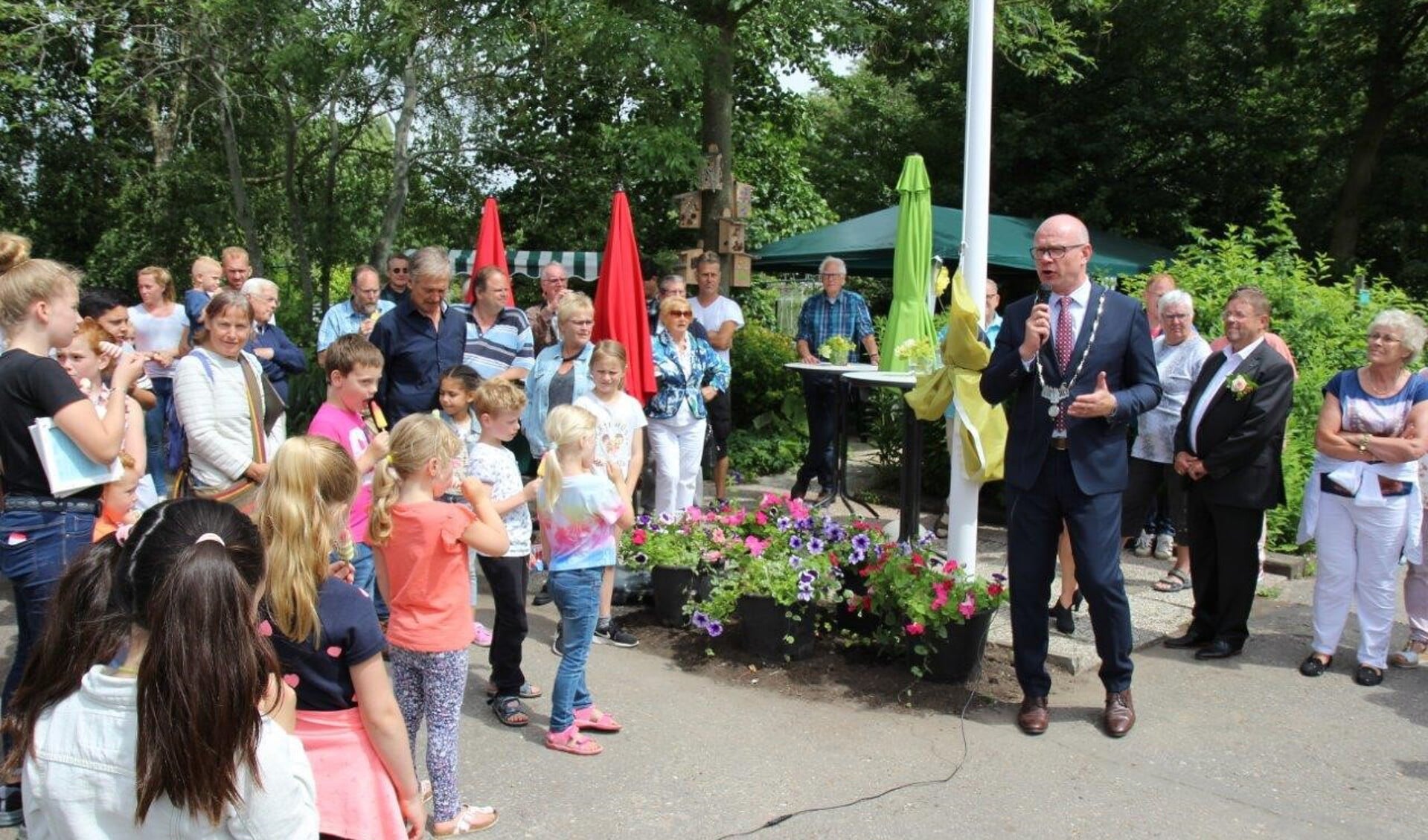 Met het hijsen van een nieuwe vlag door burgemeester Klaas Tigelaar werd het feest geopend (foto Ap de Heus). 