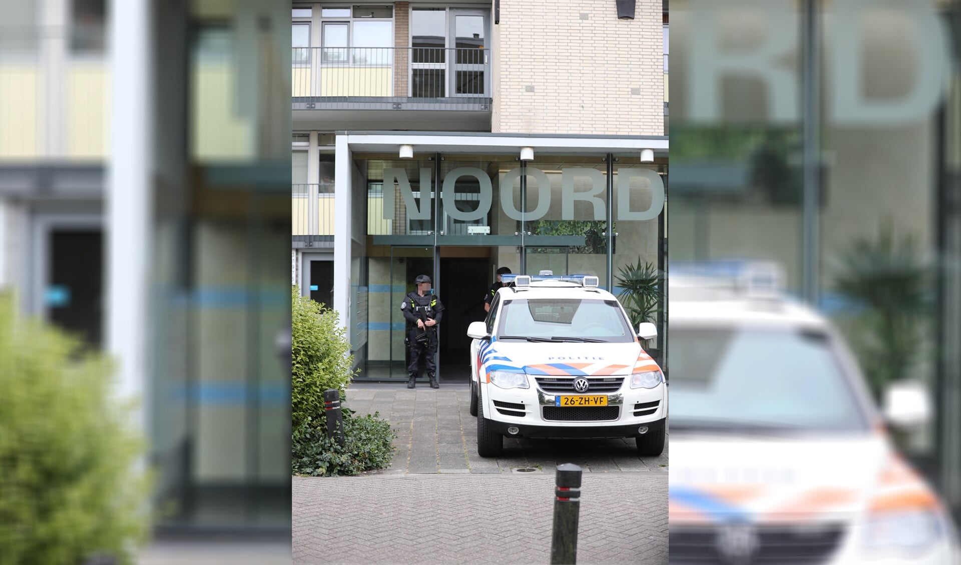 Twee ingangen van de flat werden bewaakt door zwaarbewapende politiemensen. (Foto: Regio15)