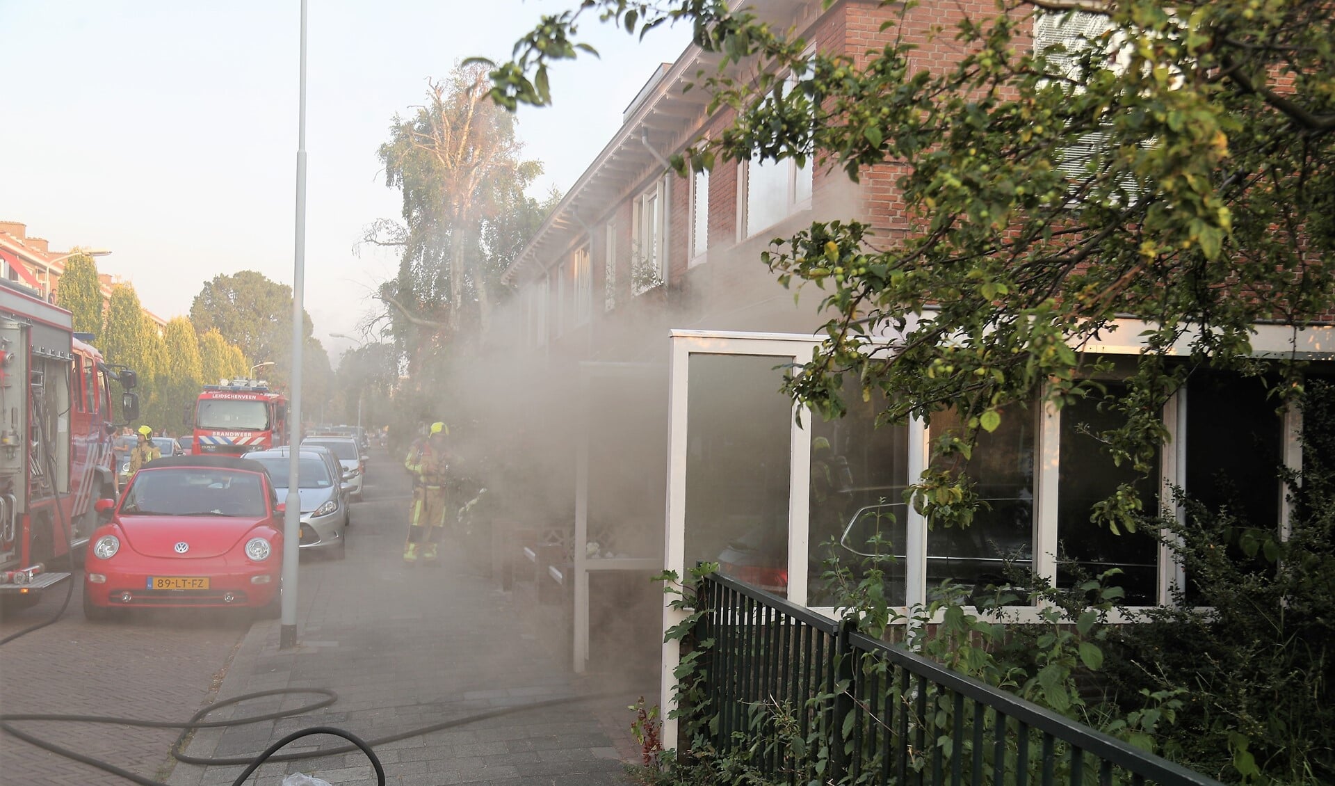 De straat hangt vol rook door de keukenbrand (foto: Rene Hendriks/Regio15).
